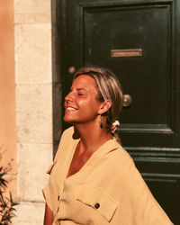 Portrait of woman standing against wall