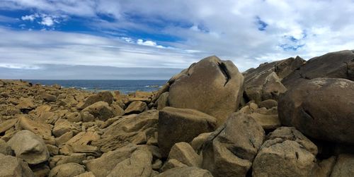 Panoramic view of rocks on beach against sky