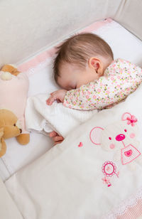 High angle view of baby sleeping in bed
