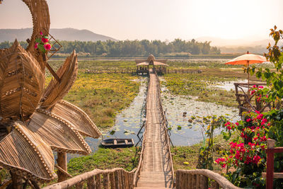 The wooden hut with long wooden bridge among the lotus flower fields at ban nam thong village.