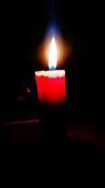 Close-up of lit candle in dark room