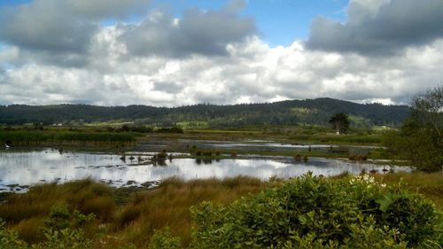 Scenic view of lake against cloudy sky