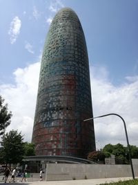 Low angle view of modern building against cloudy sky