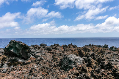 Rocks on beach against sky