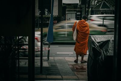 Rear view of men walking on street in city