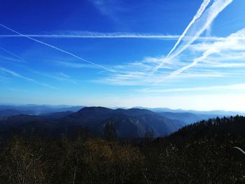 Scenic view of mountains against blue sky