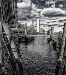 Bridge over river in city against sky