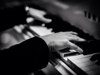 Cropped hands of person playing piano