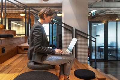 Side view of young man sitting on chair