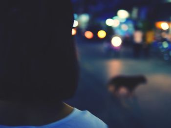 Rear view of woman with dog at night