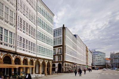 People on street amidst buildings in city