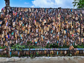 Multi colored umbrellas hanging by wall against sky