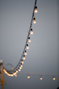 Low angle view of illuminated hanging against sky