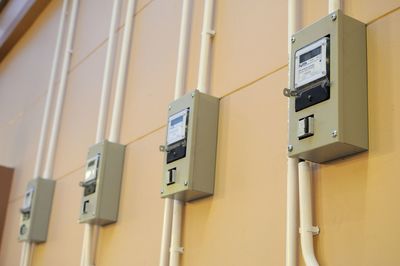 Low angle view of electric meter boxes on wall