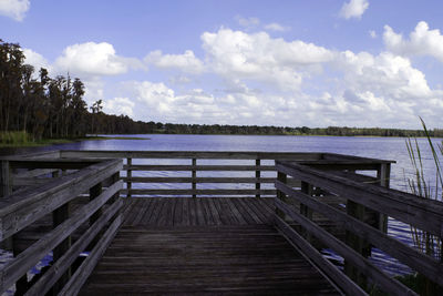 Wooden pier over lake against sky