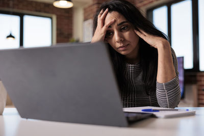 Businesswoman using laptop on table