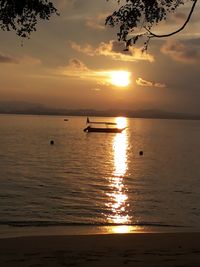 Silhouette of boats in sea at sunset