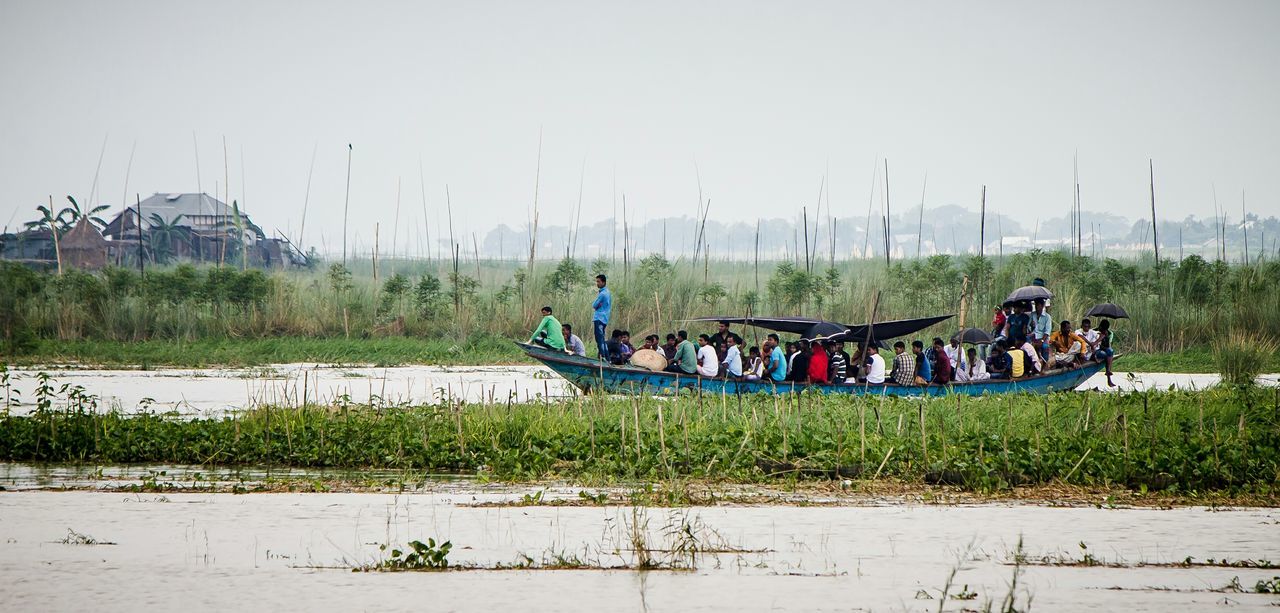 grass, mode of transport, clear sky, transportation, field, landscape, nautical vessel, nature, tranquil scene, men, tranquility, day, sky, copy space, outdoors, boat, moored, scenics, green color