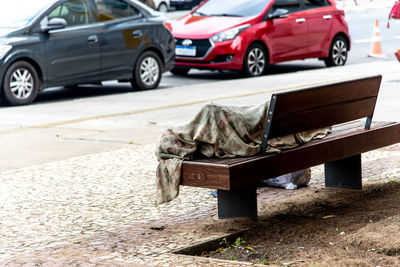 A homeless man is seen sleeping on a wooden bench in the comercio neighborhood 
