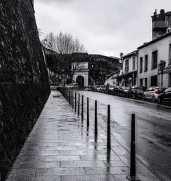 Sidewalk in city against sky