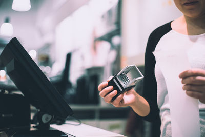 Midsection of man using mobile phone