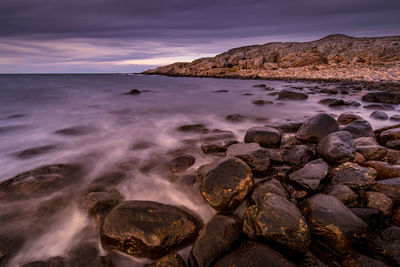 Scenic view of rocks on beach against sky