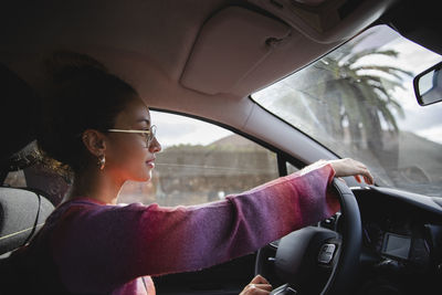 Woman wearing eyeglasses driving car