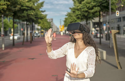 Woman standing on mobile phone in city