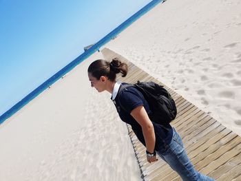 Mid adult woman standing on beach against sky