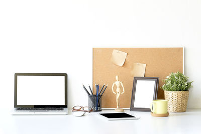 Low angle view of laptop on table against white background