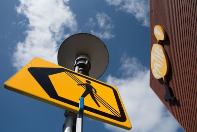 Low angle view of road sign against sky