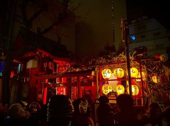 People on illuminated street at night