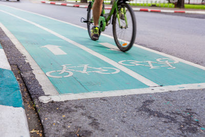Low section of man cycling on road