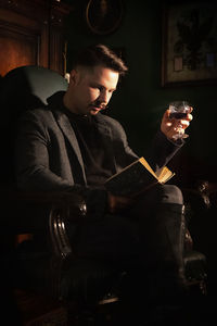 Full length of young man sitting at home