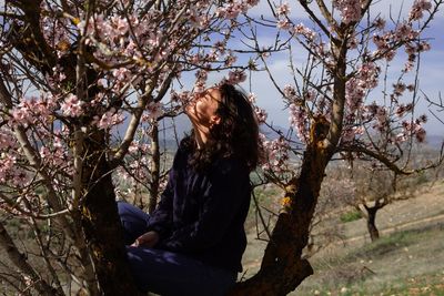 Side view of woman looking at tree