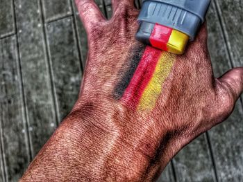 Close-up of person holding multi colored human hand