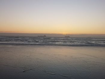 Scenic view of beach against sky at sunset