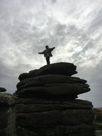Low angle view of man standing on rock
