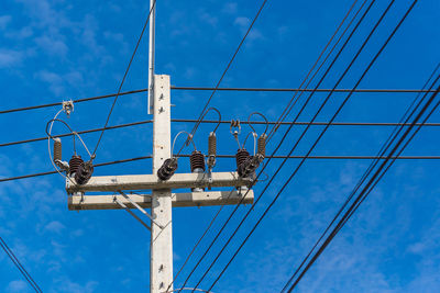 Low angle view of power lines against blue sky