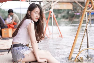 Portrait of beautiful young woman sitting outdoors