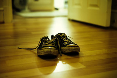 Close-up of dirty shoes on floor at home