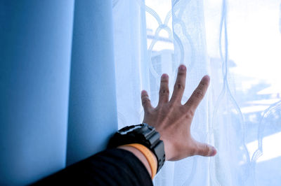 Cropped hand by window