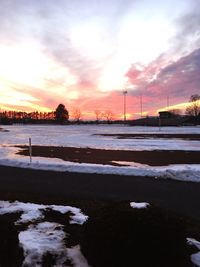 Frozen lake against sky during sunset
