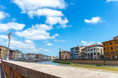 Buildings by canal against sky