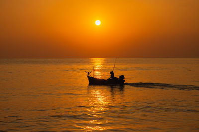 Fishermen in rayong, thailand set off on a small boat to catch fish in the evening.