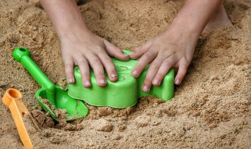 Close-up of baby hand on sand