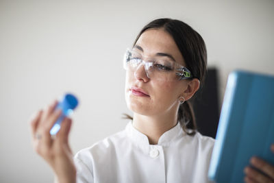 Scientist female with lab glasses, tablet and sample in a lab