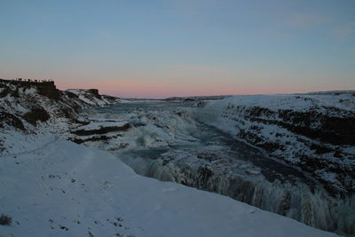 Scenic view of snowcapped mountains against clear sky during sunset