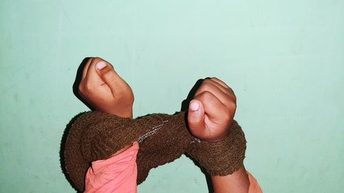 Close-up of human hand against wall