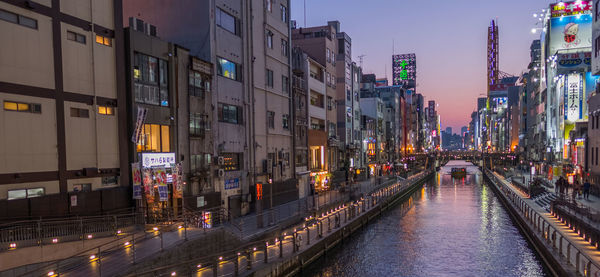 Panoramic view of city street and buildings at dusk